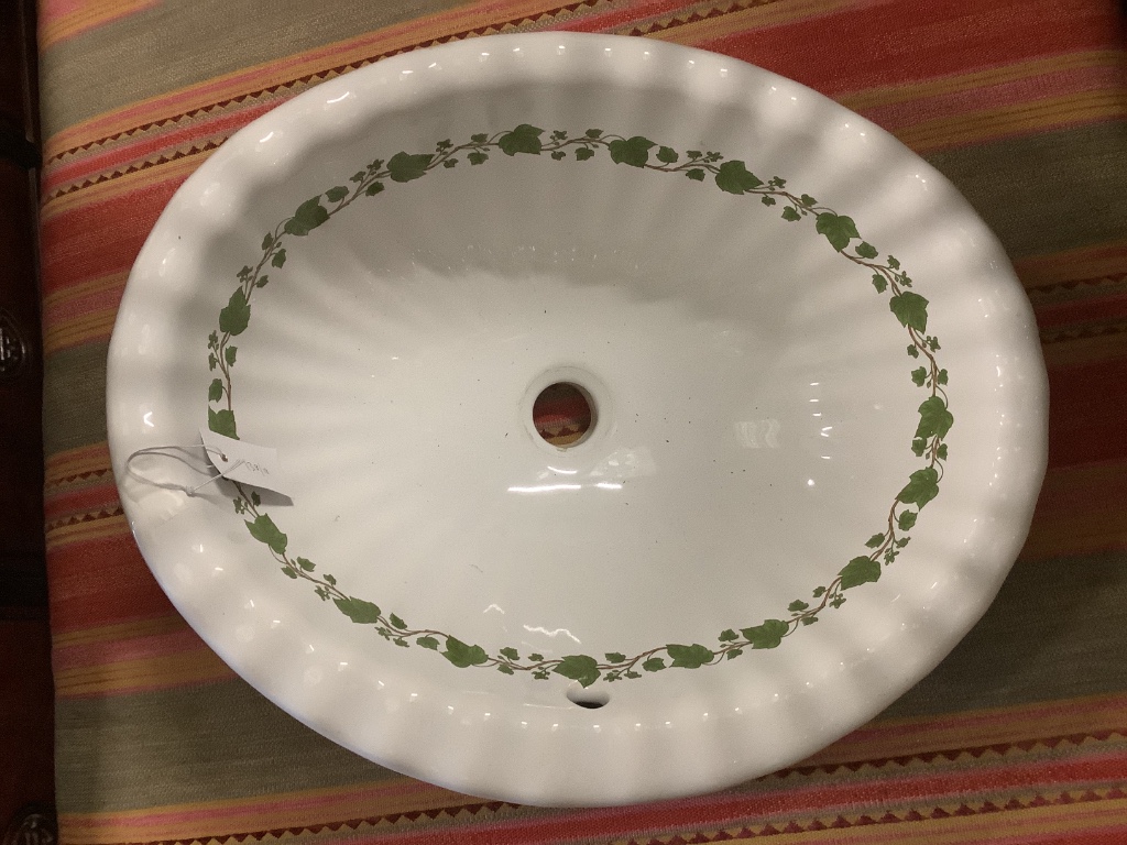 A ceramic shell sink with green ivy detail, width 52cm, depth 42cm